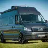 MAN TGE Next Level 7,40 Campervan mit Hochdach und schwarzen Felgen auf einer Wiese