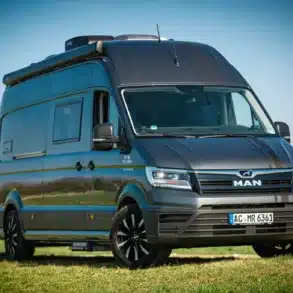 MAN TGE Next Level 7,40 Campervan mit Hochdach und schwarzen Felgen auf einer Wiese