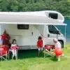 Fiamma F45s Markise am Wohnmobil, aufgespannt mit Familie beim Camping am See