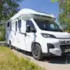 Notin Malaga JF Limited Edition 2025, teilintegriertes Reisemobil auf Fiat Ducato, vor einer grünen Landschaft geparkt