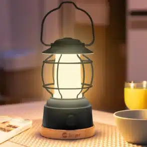 Leuchtende Berger Campinglampe auf einem Tisch im Camper, umgeben von Schale, Becher und Katalog.