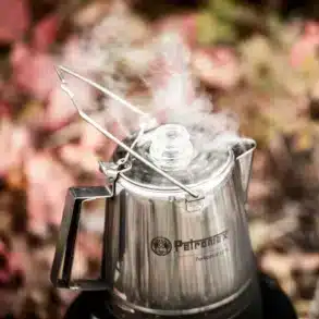 Dampfender Petromax Perkolator Perkomax aus Edelstahl mit Glasknauf in der Natur