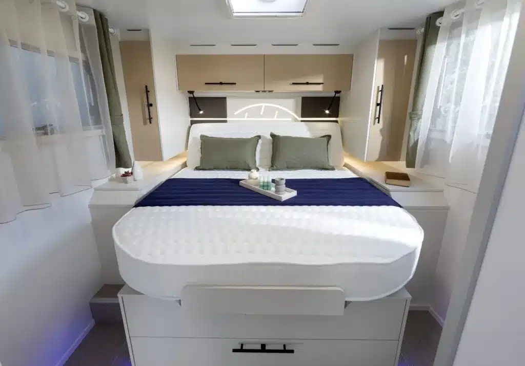 Mittelgroßes zentrales Bett im hinteren Bereich eines Reisemobils Progress Almeria CF, mit modernem Innenraum und Stauraum darunter.