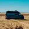 Seitenansicht des Renault Master VANtastic Kastenwagens am Strand vor blauem Himmel