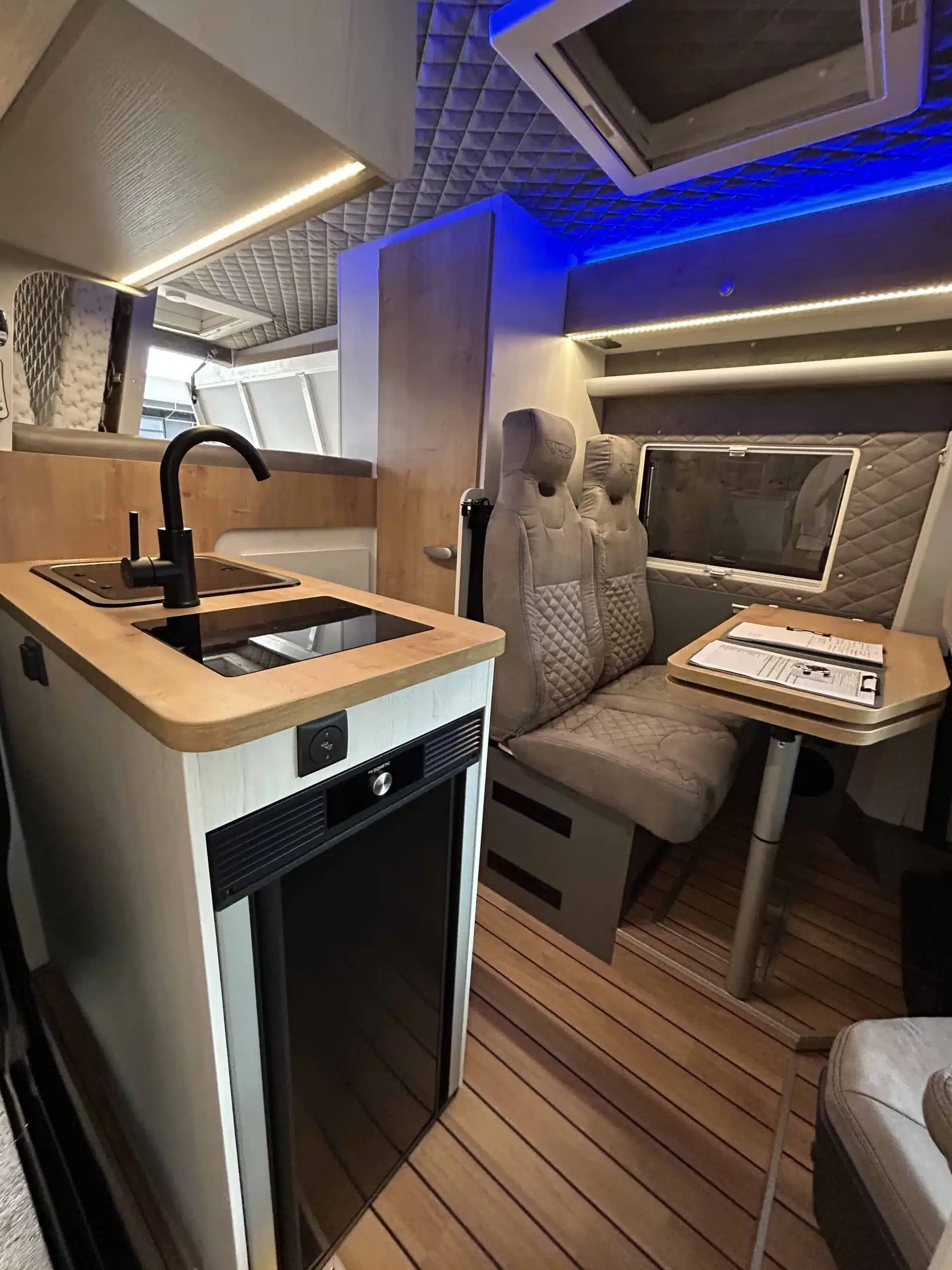 Innenraum eines Mercedes-Benz Sprinter 6,0 m, wohnlich ausgebaut von VR Motorhomes, mit Küchenzeile, Sitzgruppe und Oberlichtern