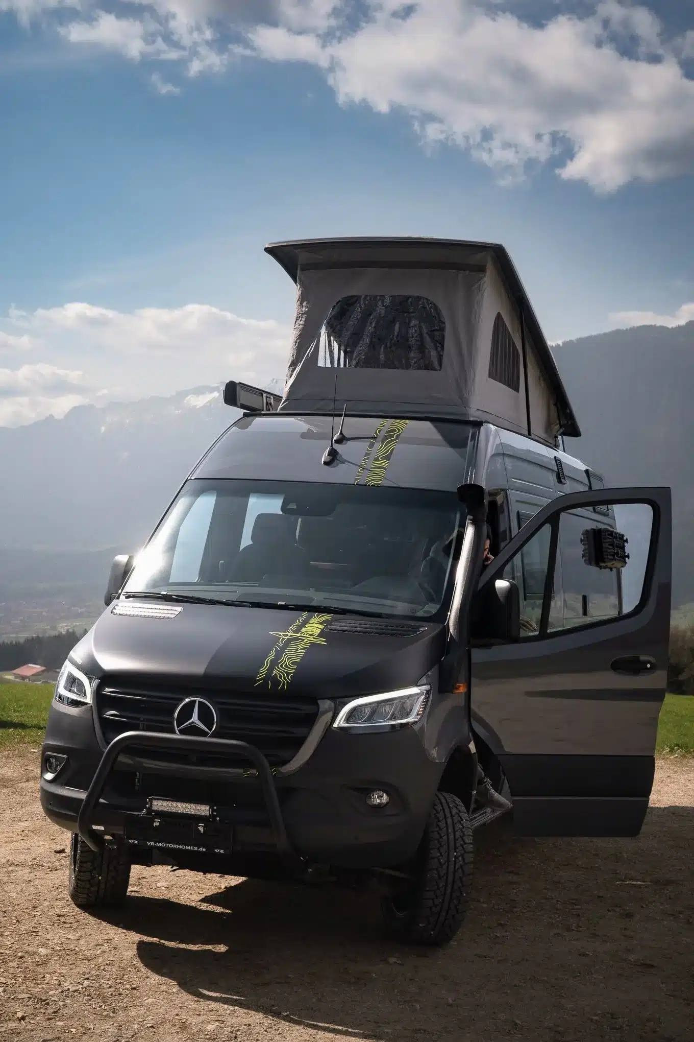 Mercedes-Benz Sprinter 7 m Camper mit geöffnetem Aufstelldach und Offroad-Ausstattung vor Alpen-Panorama.