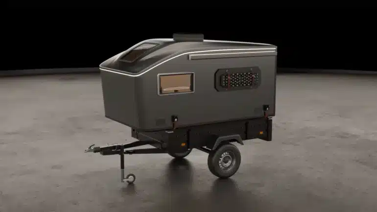 Der Vulpes S Micro-Camper von Pathless Campers auf einem Einachsanhänger in einer Studio-Umgebung