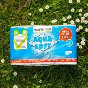 Thetford Aqua Soft Toilettenpapier Vorteilspack auf einer Wiese mit Gänseblümchen.
