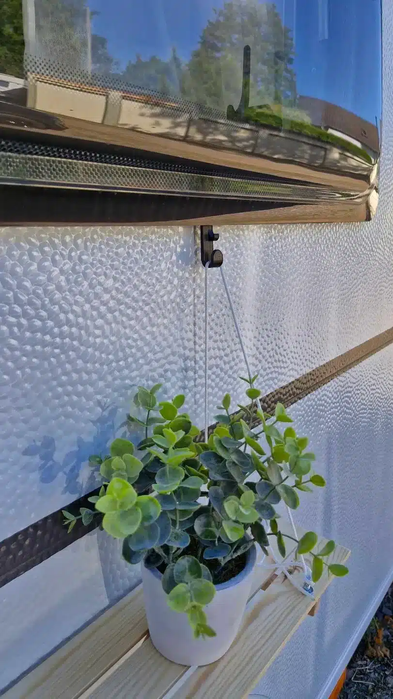 3D-gedruckter Pflanzenhalter mit Topf an einem Camperfenster montiert