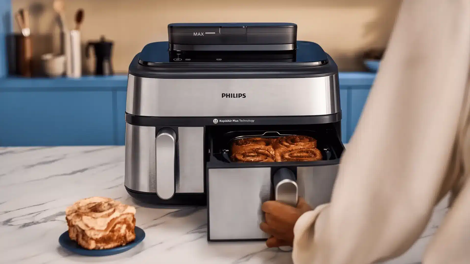 Philips Airfryer mit geöffnetem Korb und frischem Gebäck auf einer Marmorarbeitsplatte