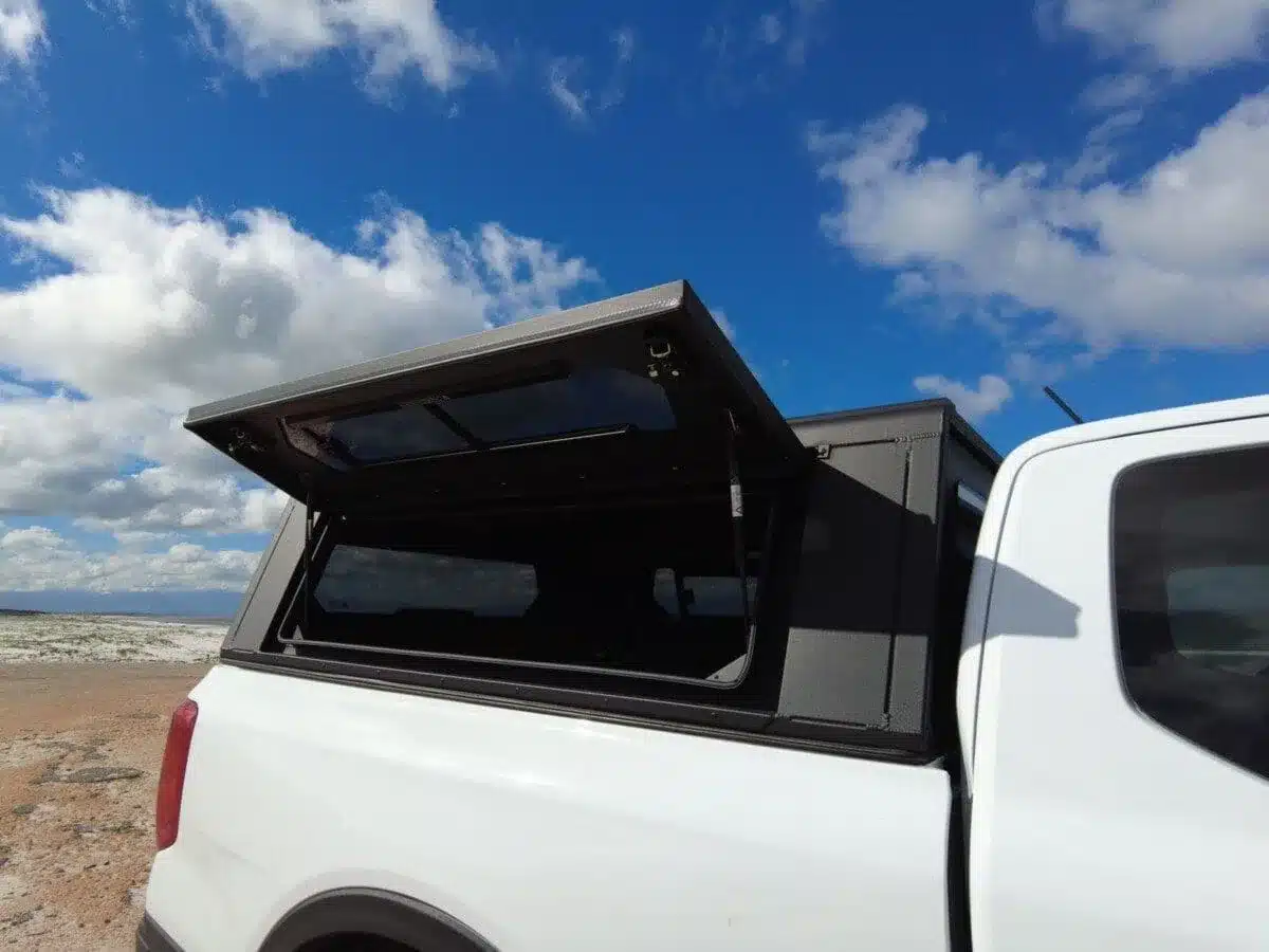 Pickup mit montiertem Contour Canopy, Heckklappe geöffnet, Landschaft im Hintergrund