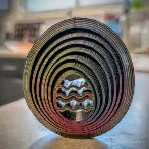 Buntes, rundes 3D-gedrucktes Deko-Objekt aus mehreren Farbschichten, fotografiert auf einem Tisch im Wohnmobil