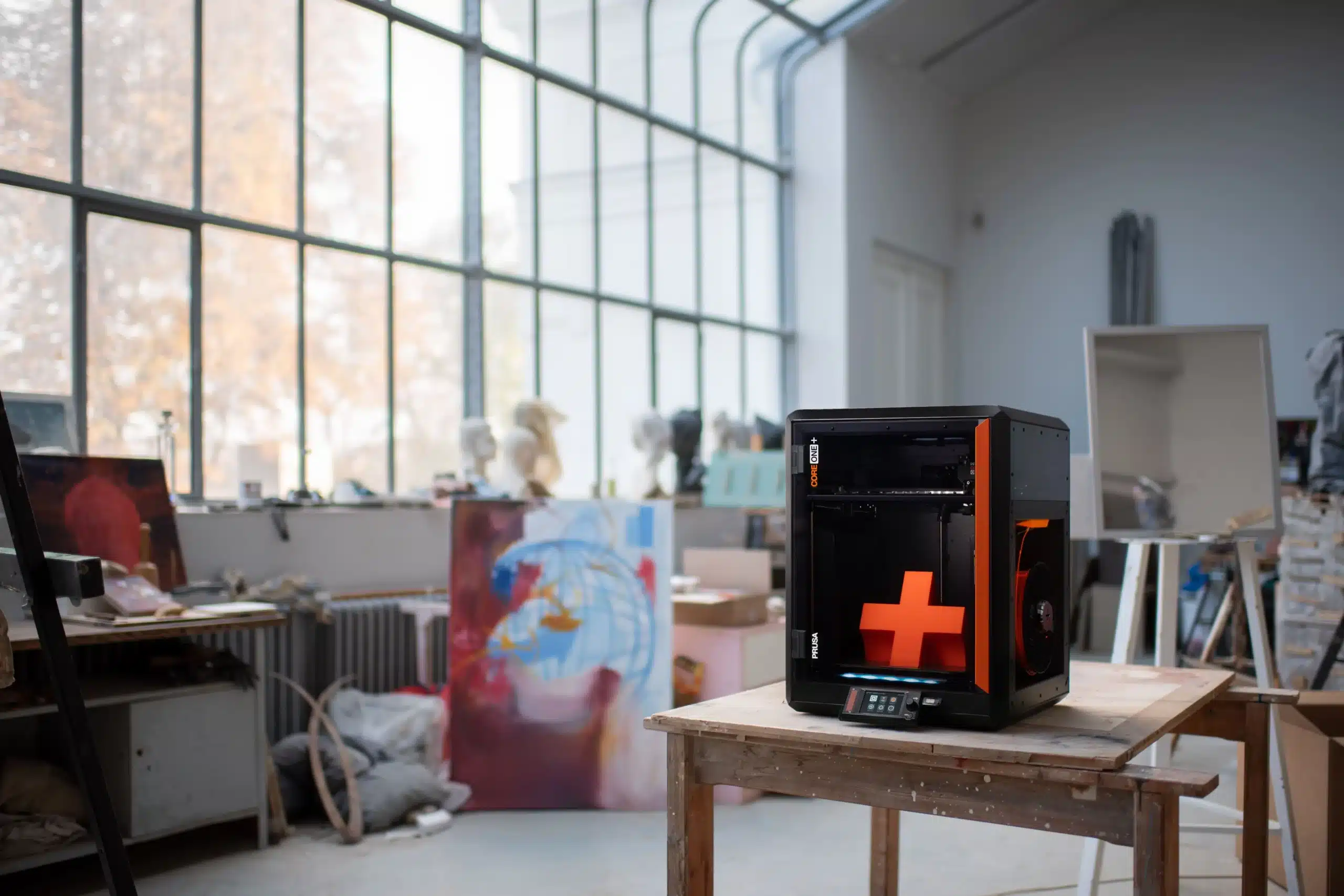 Prusa Core One+ 3D-Drucker auf Werkbank in Atelierumgebung