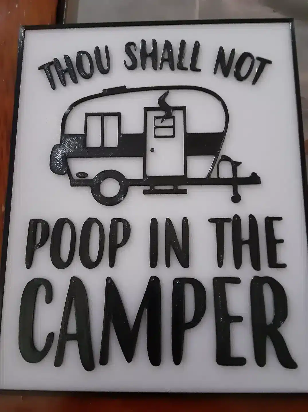 3D-gedrucktes Schild mit dem Text 'Thou Shall Not Poop In The Camper' und einem stilisierten Wohnwagenmotiv