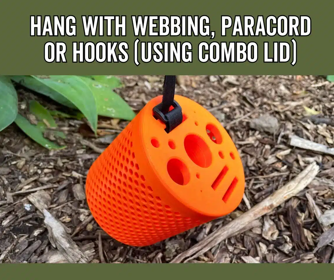 Ein orangefarbener 3D-gedruckter Behälter für Toilettenpapier hängt mithilfe eines Gurtes an einem Ast, perfekt für Camping und Outdoor-Aktivitäten.