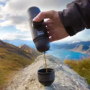 Hand bereitet mit der Wacaco Nanopresso Espresso vor Bergpanorama zu.