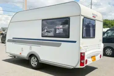 Adria Altea 390PS Wohnwagen, Seiten- und Rückansicht, auf einem Parkplatz