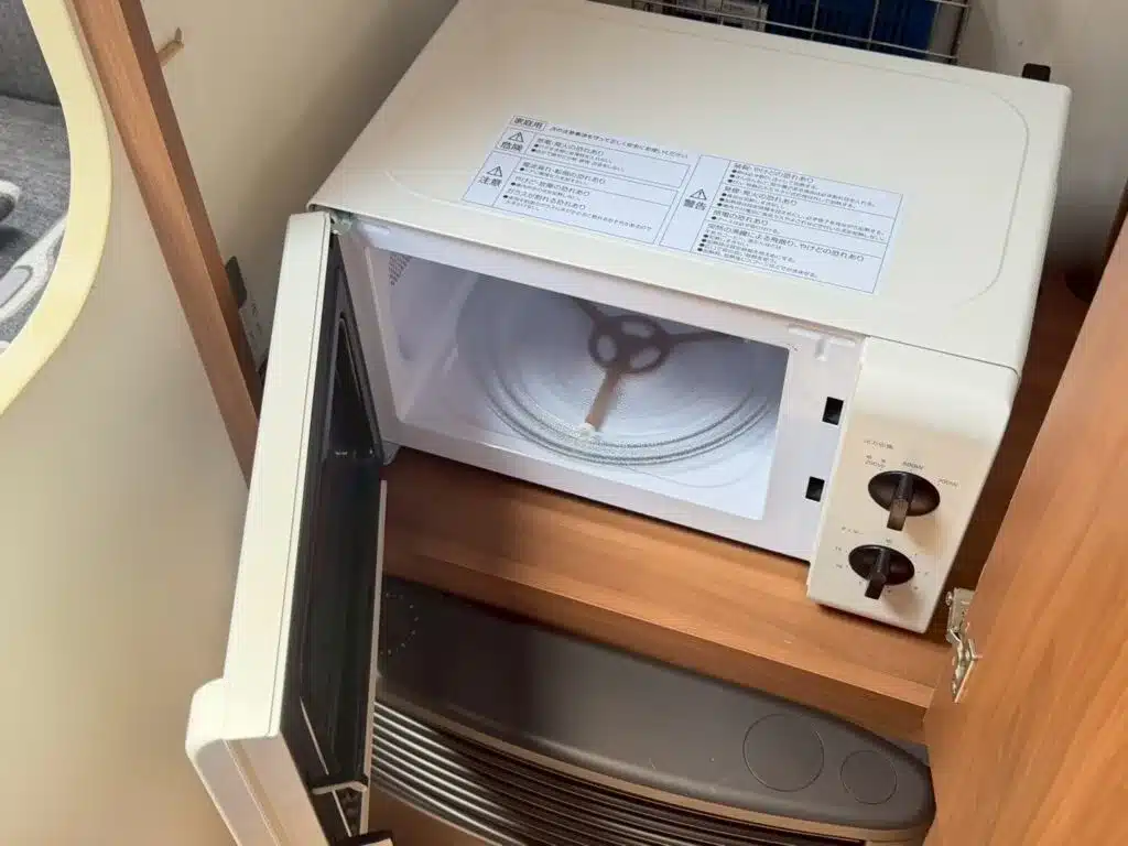 Geöffnete Mikrowelle im Innenraum des Adria Altea 390PS Caravans