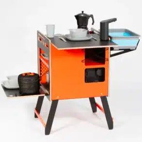 Mobile Campingküche ADVENTURE mit Geschirr, Espressokocher, Waschbecken und Stauraum, aufgebaut auf hellem Hintergrund.