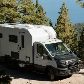 AEONrv Offroad-Camper auf unbefestigtem Gelände zwischen Bäumen