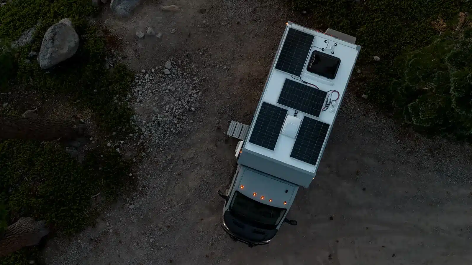 Luftaufnahme des AEONrv mit Solarpanels auf dem Dach in unwegsamem Gelände