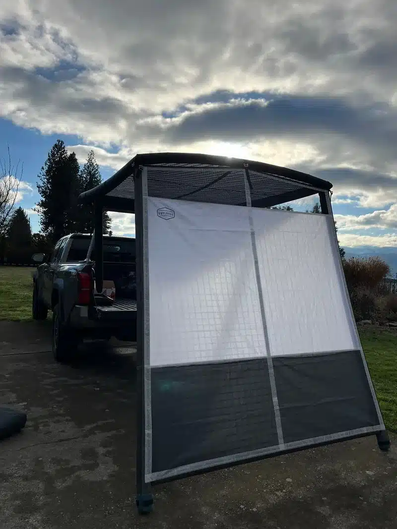 DAYLODGE Annex Bundle mit aufblasbarer Wand an einem Pick-up installiert, unter bewölktem Himmel