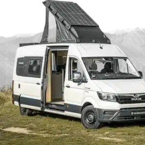 Altiplano Campervan MAN TGE L4 mit Solardach und offenem Einstieg auf einer Wiese vor Bergkulisse.