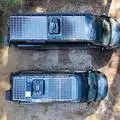 Zwei Mercedes-Kastenwagen mit individuell angepasstem Camper-Ausbau, Luftaufnahme mit Solarpanels auf den Dächern