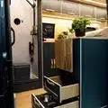 Blick in den Wohn- und Küchenbereich eines Beyond2c Kastenwagens mit offenen Schubladen und Sicht auf das Bad.