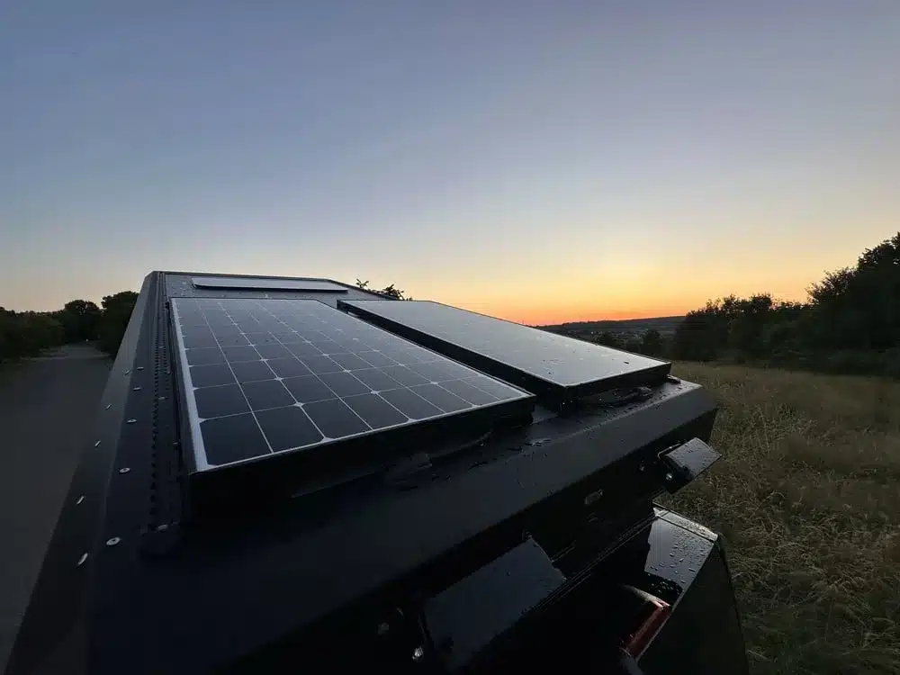 Campany-Aufstelldach mit montierten Solarmodulen bei Sonnenuntergang auf einem Kastenwagen.