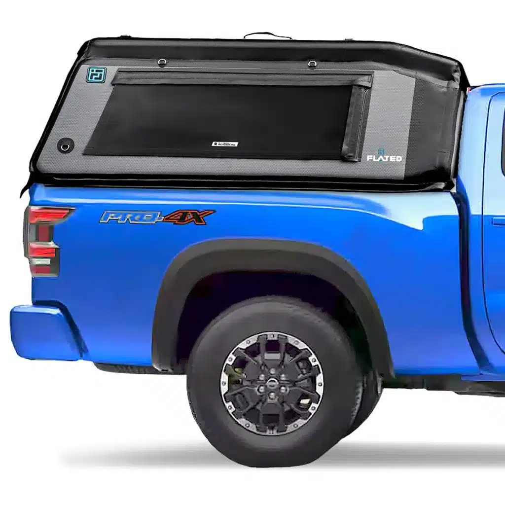 Seitliche Ansicht eines blauen Pick-ups mit montiertem FLATED Air-Topper MR60 auf der Ladefläche.