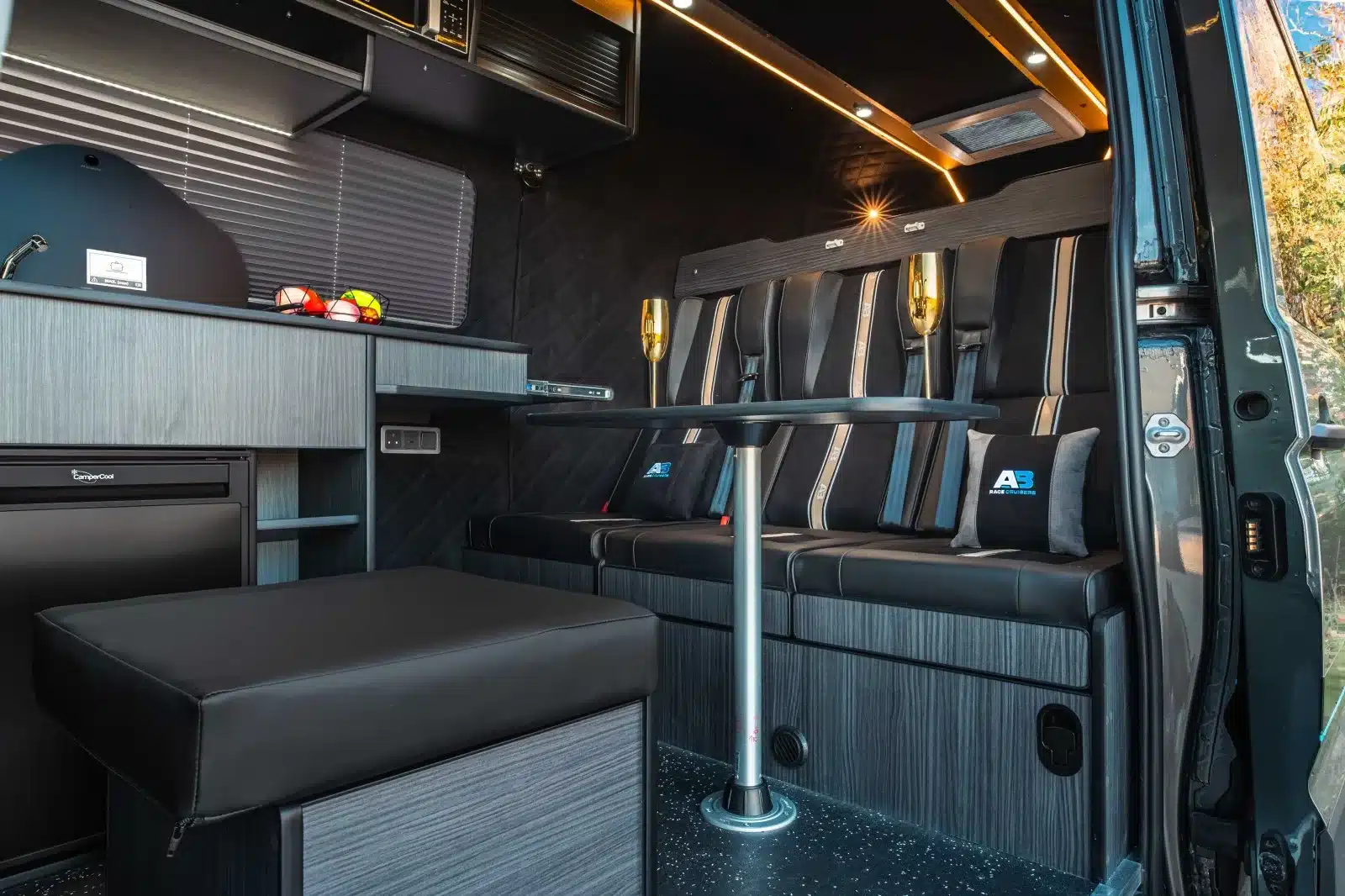 Wohnbereich im MAN TGE 180 Campervan mit Dreisitzer-Sofa, Tisch und Küche