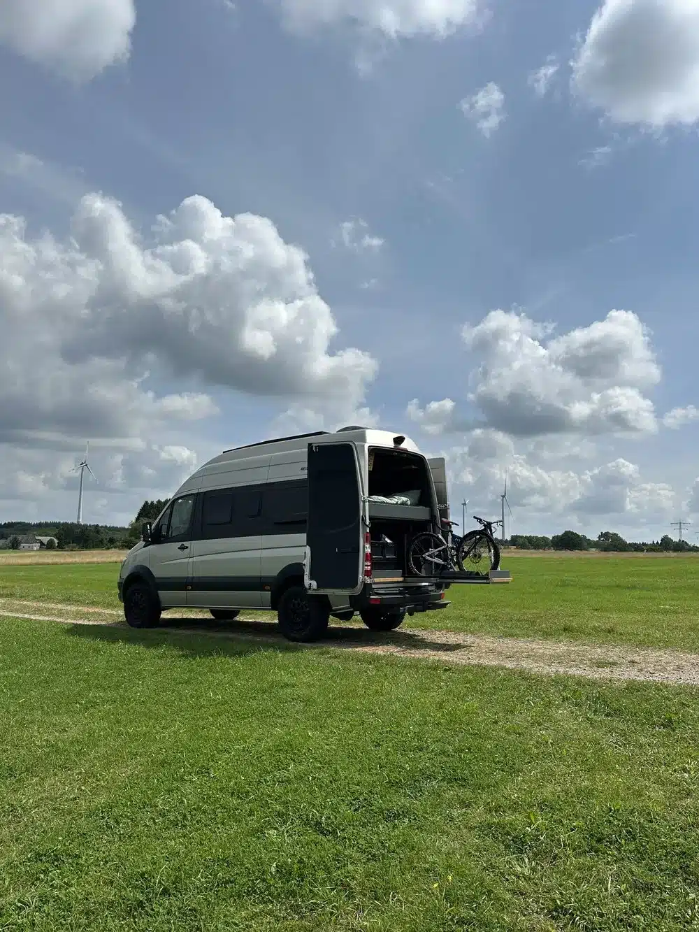 Kastenwagen Sportive mit offener Heckgarage und Fahrrad in ländlicher Umgebung