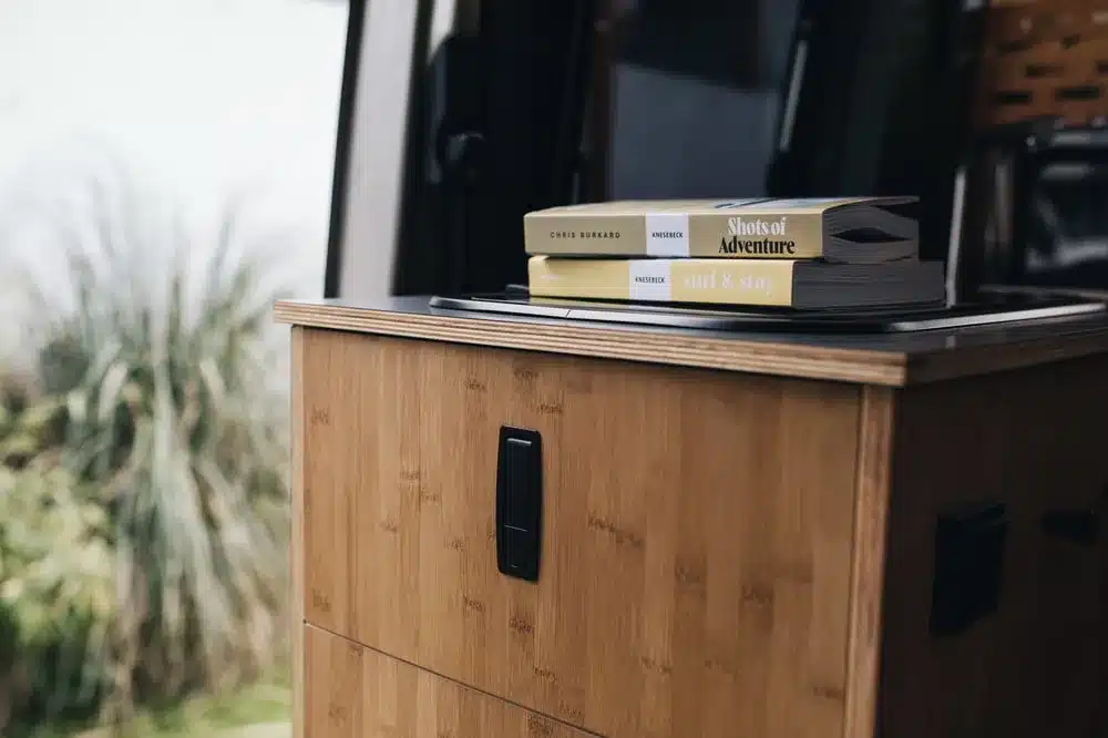 Möbelmodul aus Echtholzfurnier mit Büchern im Innenraum eines Campervans Sportive