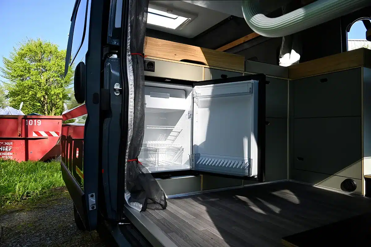 Heckbereich des Rocket One L 2.4 P Campervans mit geöffneter Tür und Kühlschrank
