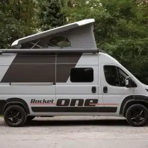 ROCKET ONE M Campervan mit geöffnetem Aufstelldach im Wald, Seitenansicht