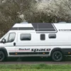 Rocket Space Kastenwagen seitlich auf Landstraße mit Hochdach und großem Schriftzug