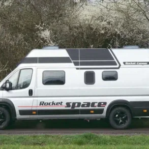 Rocket Space Kastenwagen seitlich auf Landstraße mit Hochdach und großem Schriftzug