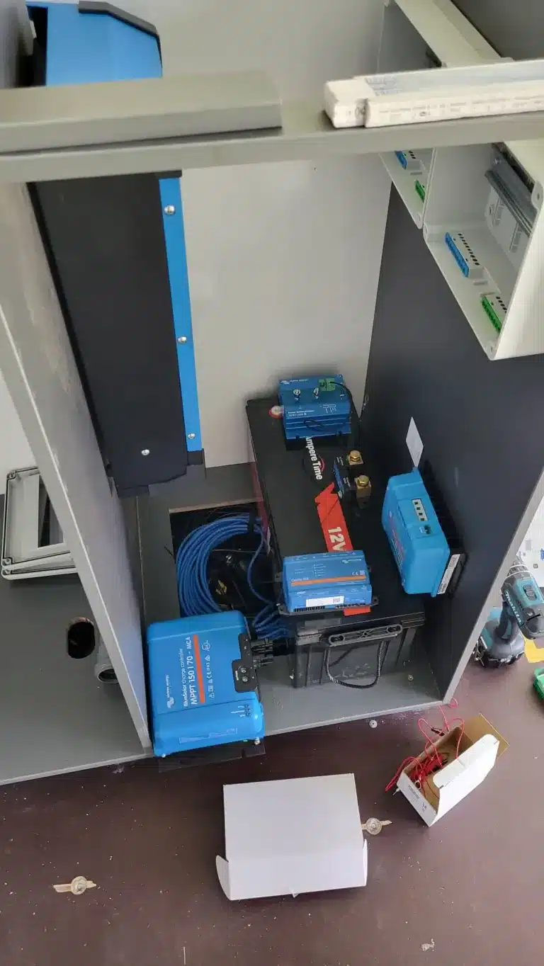 Technikmodul mit 12V-Batterie, Ladegeräten und Verkabelung im Spikes-Caravan für autarkes Reisen.