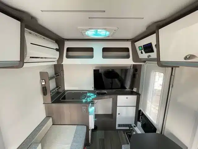 Innenansicht des Sunday Compact C1 Campers mit Sitzbank, Küchenzeile, Stauraum und technischer Ausstattung.