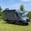 Autark Runner R9 Allradwohnmobil Mercedes-Benz Sprinter 2023 auf Wiese, außenansicht mit Markise und Geländebereifung.
