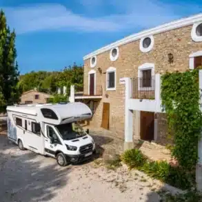 Benimar S324 UP Reisemobil vor einem Landhaus in mediterraner Umgebung