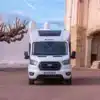 Frontansicht des Benimar Y840 Wohnmobils auf Ford-Basis vor einem Gebäude.