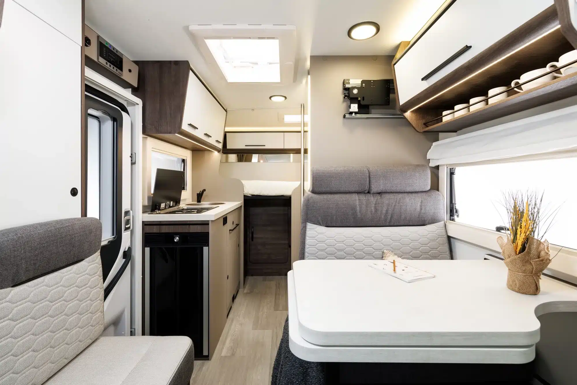 Innenansicht des Benimar Y840 Reisemobils mit Sitzbereich, Esstisch, Küche und Schlafplatz