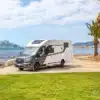Benimar Y861 Wohnmobil am Strand mit Palmen und Meer im Hintergrund
