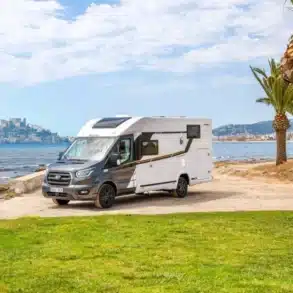 Benimar Y861 Wohnmobil am Strand mit Palmen und Meer im Hintergrund