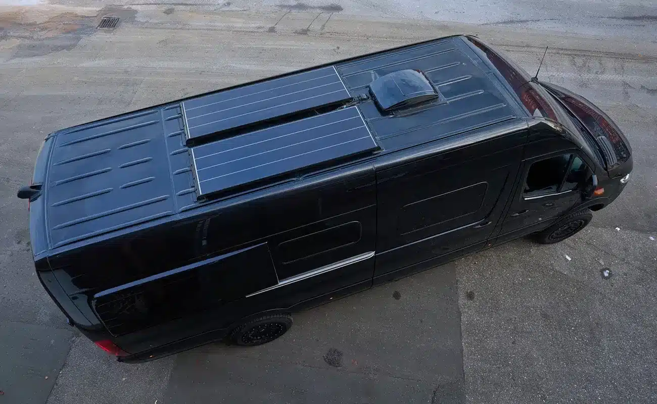 Schwarzer Mercedes-Benz Sprinter Campervan Black Gorilla mit Solarpanelen auf dem Dach, von oben gesehen.