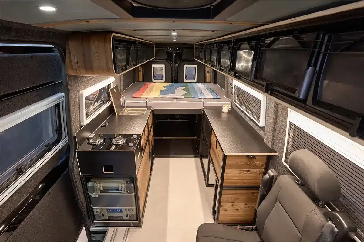 Innenraum des Black Gorilla Campervans mit flexibler Bettlösung, Küche und Stauraum auf Basis eines Mercedes-Benz Sprinter 4x4.