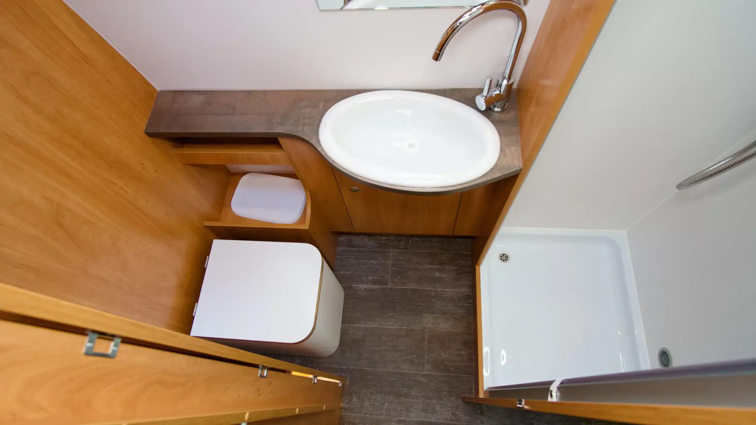Badezimmer im Bresler 694 DF Kastenwagen mit Dusche, Waschbecken und moderner Toilette