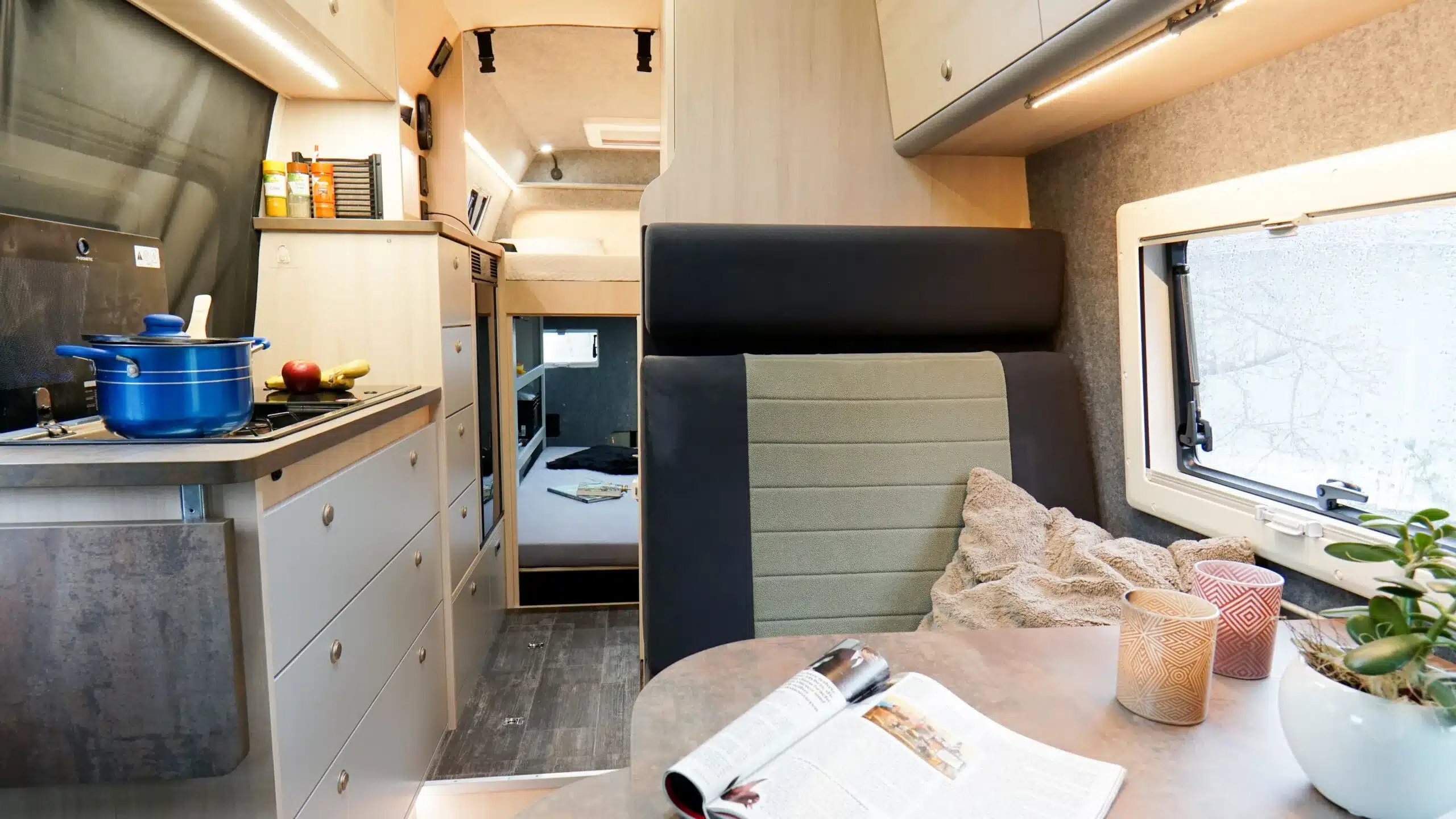 Moderner und wohnlicher Innenraum des Bresler 694 DG – Indi Cross mit Küchenzeile, Sitzgelegenheit, Tisch und Blick zum Bett